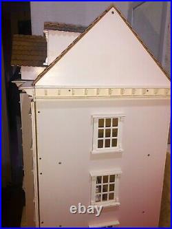 4 storey pink wooden dolls house inc. Some wooden dolls and furniture