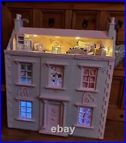 Wooden dolls house, fully furnished, with a family of dolls and soft furnishings