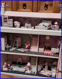 Wooden dolls house, fully furnished, with a family of dolls and soft furnishings